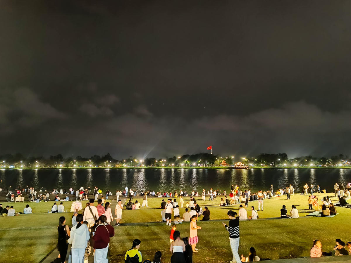 Rất đông người dân tập trung ở bãi cỏ phía bờ nam sông Hương để chào đón thời khắc Giao thừa. Ảnh: N.Q.