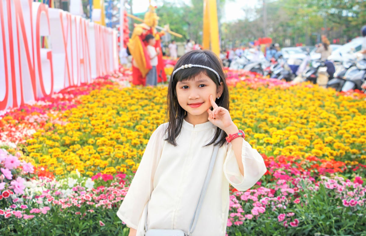 Một em nhỏ chụp ảnh lưu niệm du xuân đầu năm mới. Ảnh: Chí Đại.