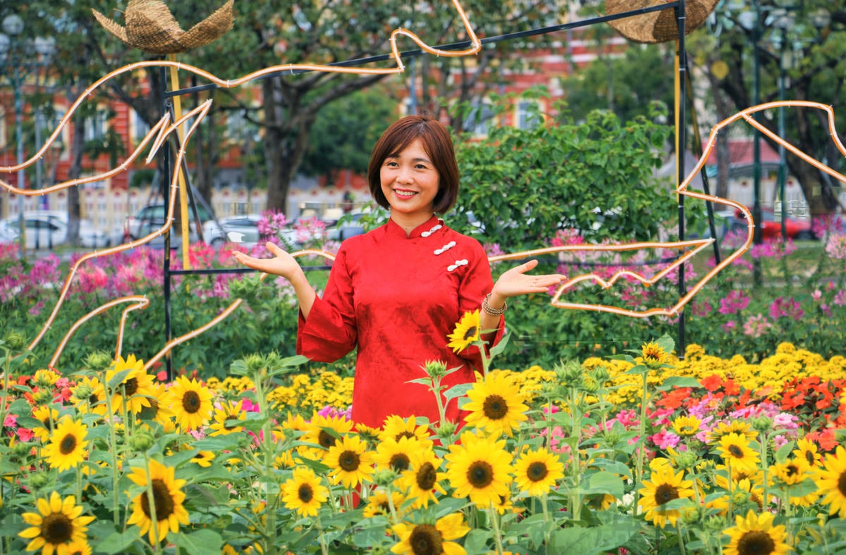 Một bạn gái chụp ảnh bên vườn hoa rực rỡ nhiều màu sắc. Ảnh: Nguyễn Tín.