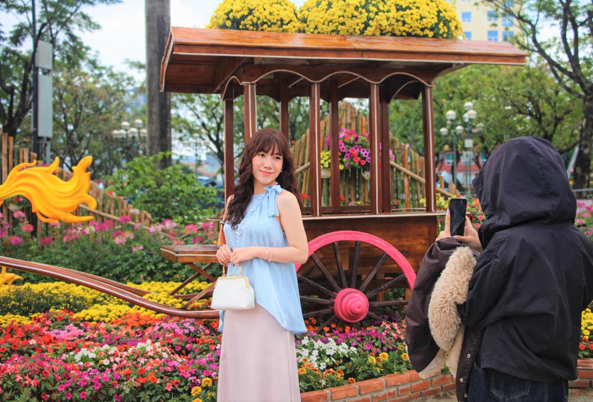 Các bạn trẻ tạo dáng bên tiểu cảnh rừng hoa rực rỡ màu sắc tại Quảng trường 24/3. Ảnh: Chí Đại.