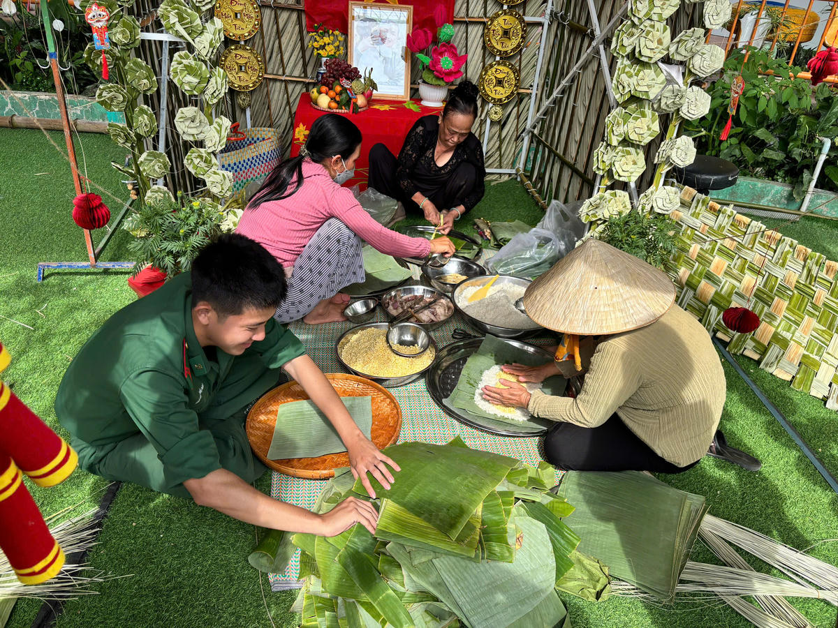 Cán bộ, chiến sỹ Đồn Biên phòng Cửa khẩu Cảng Hòn Chông phối hợp với Trường Tiểu học Bình An (xã Kiên Lương) gói bánh tét để trao tặng cho các học sinh có hoàn cảnh khó khăn. (ảnh: BPHC)