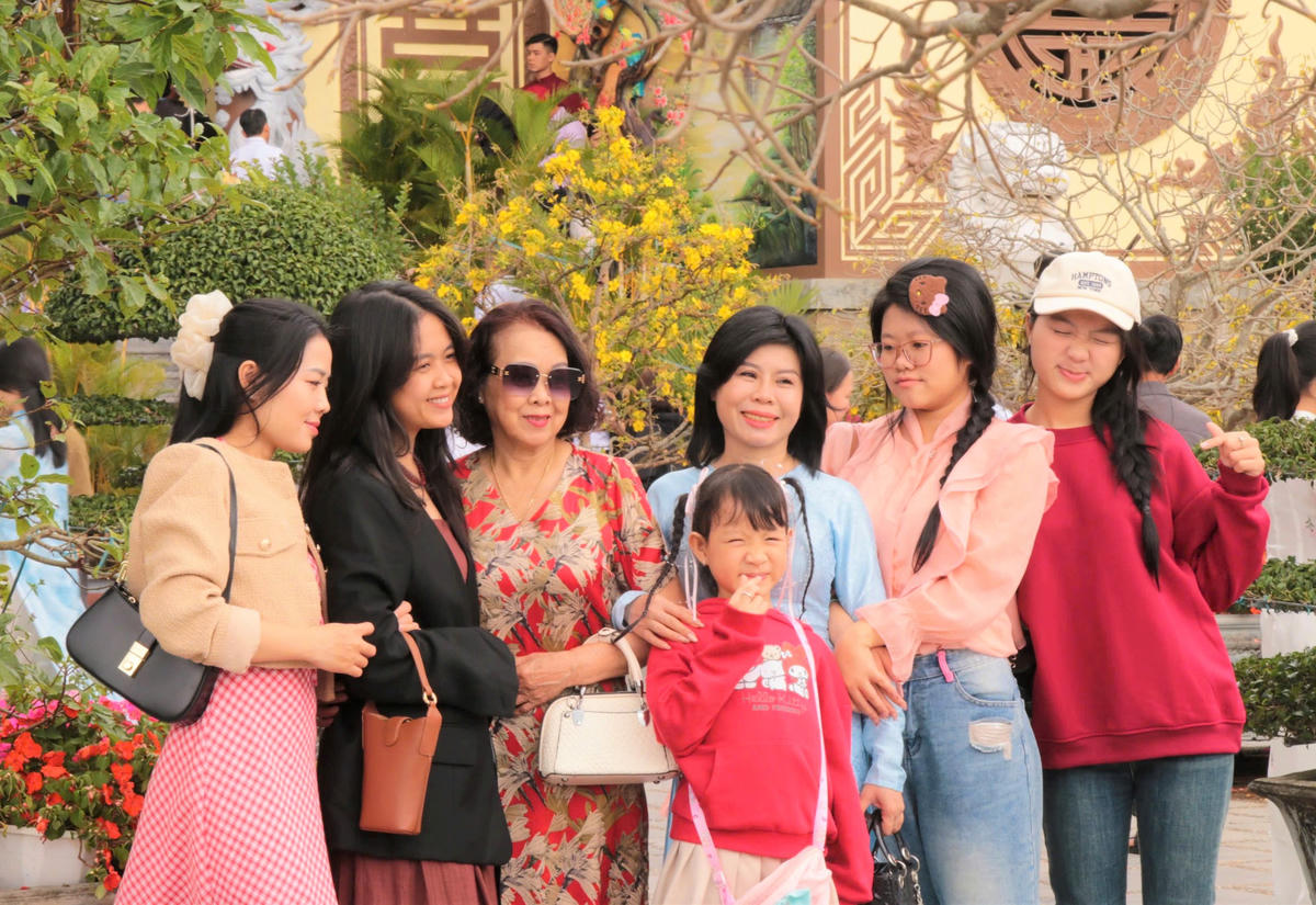 Một gia đình chụp ảnh lưu niệm đầu năm mới tại chùa Linh Ứng. Ảnh: CV.