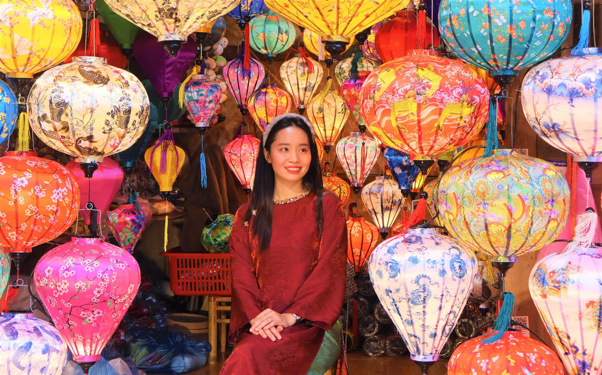 Một cố gái chụp ảnh bên những chiếc đèn lồng đầy màu sắc rức rỡ. Ảnh: Chí Đại.