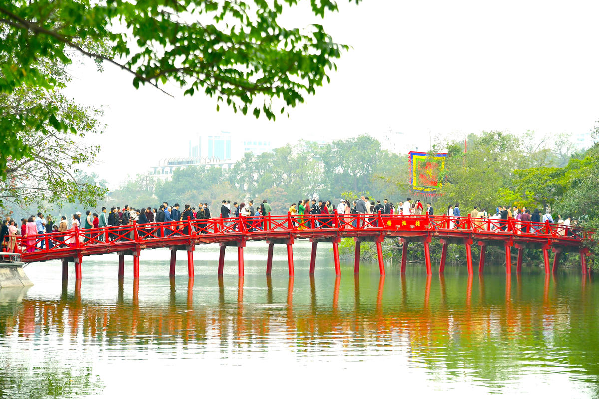 Biểu tượng văn hóa của Hà Nội soi bóng xuống mặt hồ xanh, trở thành điểm dừng chân của đông đảo người dân và du khách.  Ảnh: Phạm Sỹ.