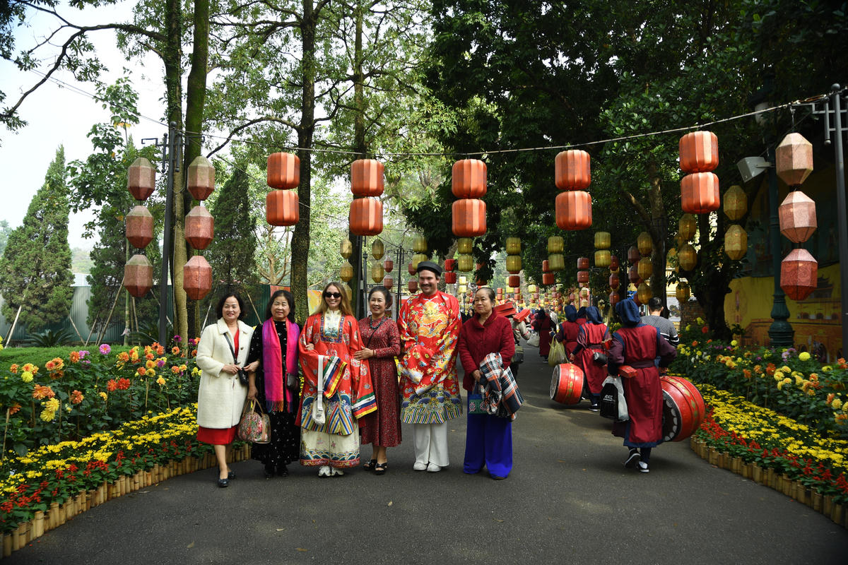 Du khách thích thú dạo bước, lưu giữ khoảnh khắc tại đường hoa Hoàng thành Thăng Long. Ảnh: Phạm Sỹ.