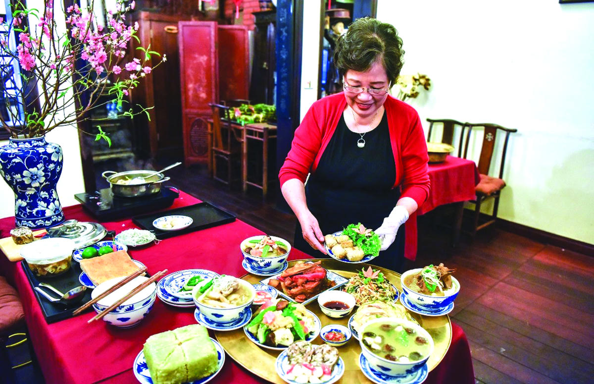 Nghệ nhân Hà Thị Vinh giới thiệu về mâm cỗ Bát Tràng. Ảnh: Hương Thu.