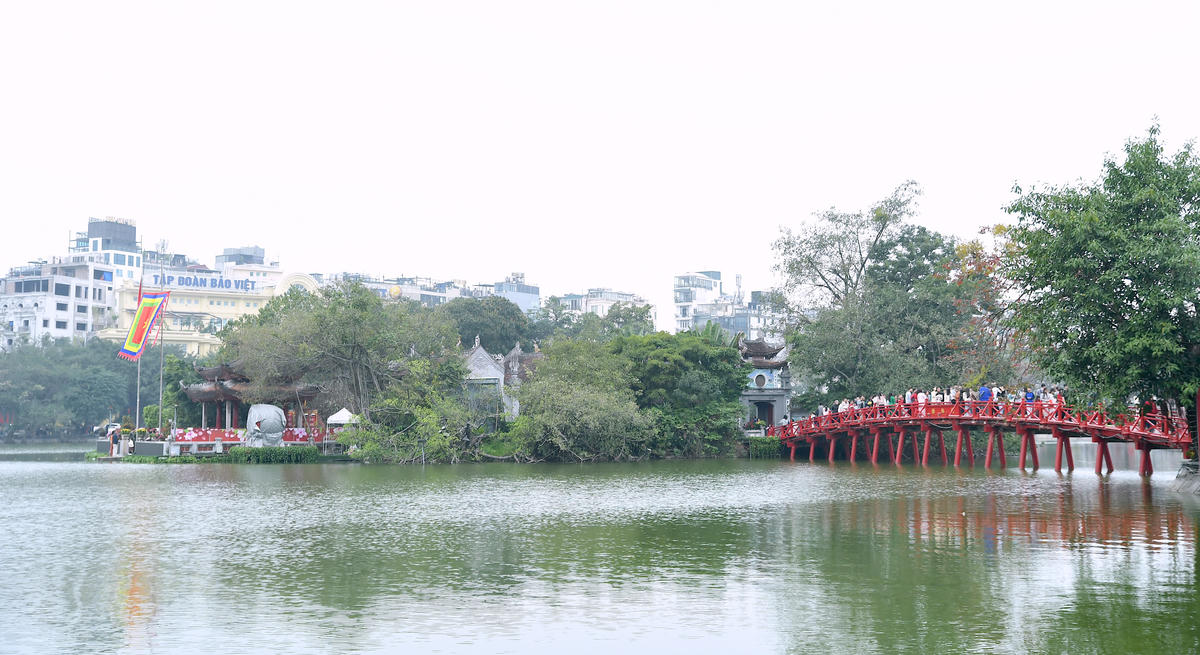 Cầu Thê Húc đỏ thắm nổi bật giữa nền trời xuân.  Ảnh: Phạm Sỹ.