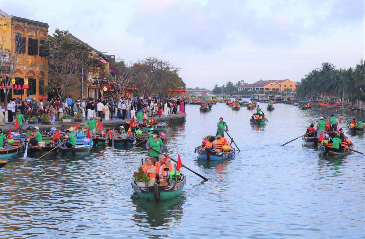 Du khách ngôi ghe trên sông Hoài ngắm phố cổ Hội An. Ảnh: Tấn Thành.