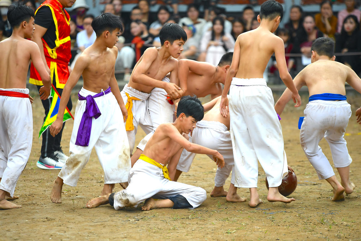 Những pha tranh cầu hồn nhiên mà quyết liệt của các em nhỏ làm không khí sân đình thêm rộn ràng, tiếp nối mạch nguồn truyền thống thượng võ của làng. Ảnh: Phạm Sỹ.