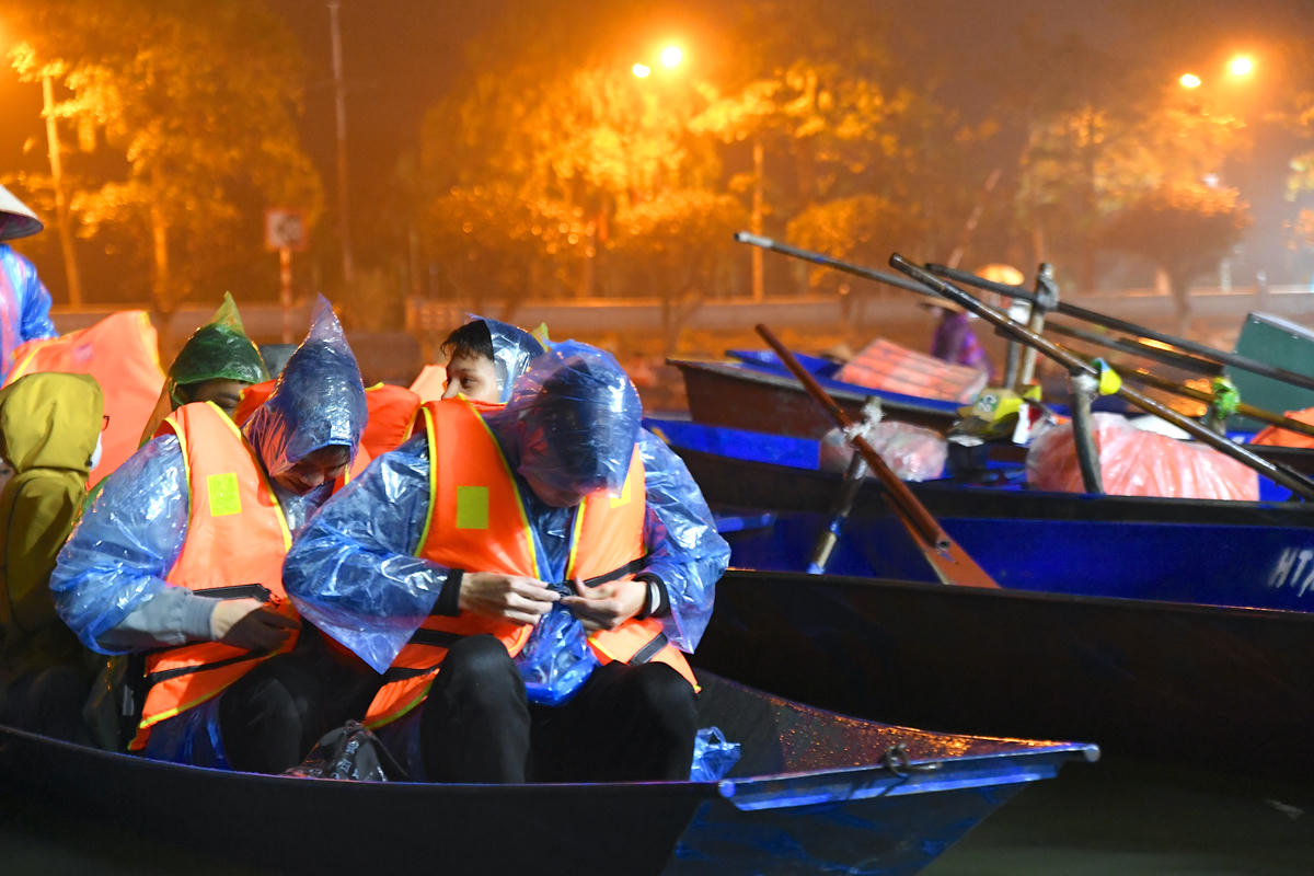 Du khách nghiêm túc chấp hành hướng dẫn của chủ đò về việc mặc áo phao. Ảnh: Phạm Sỹ.
. 