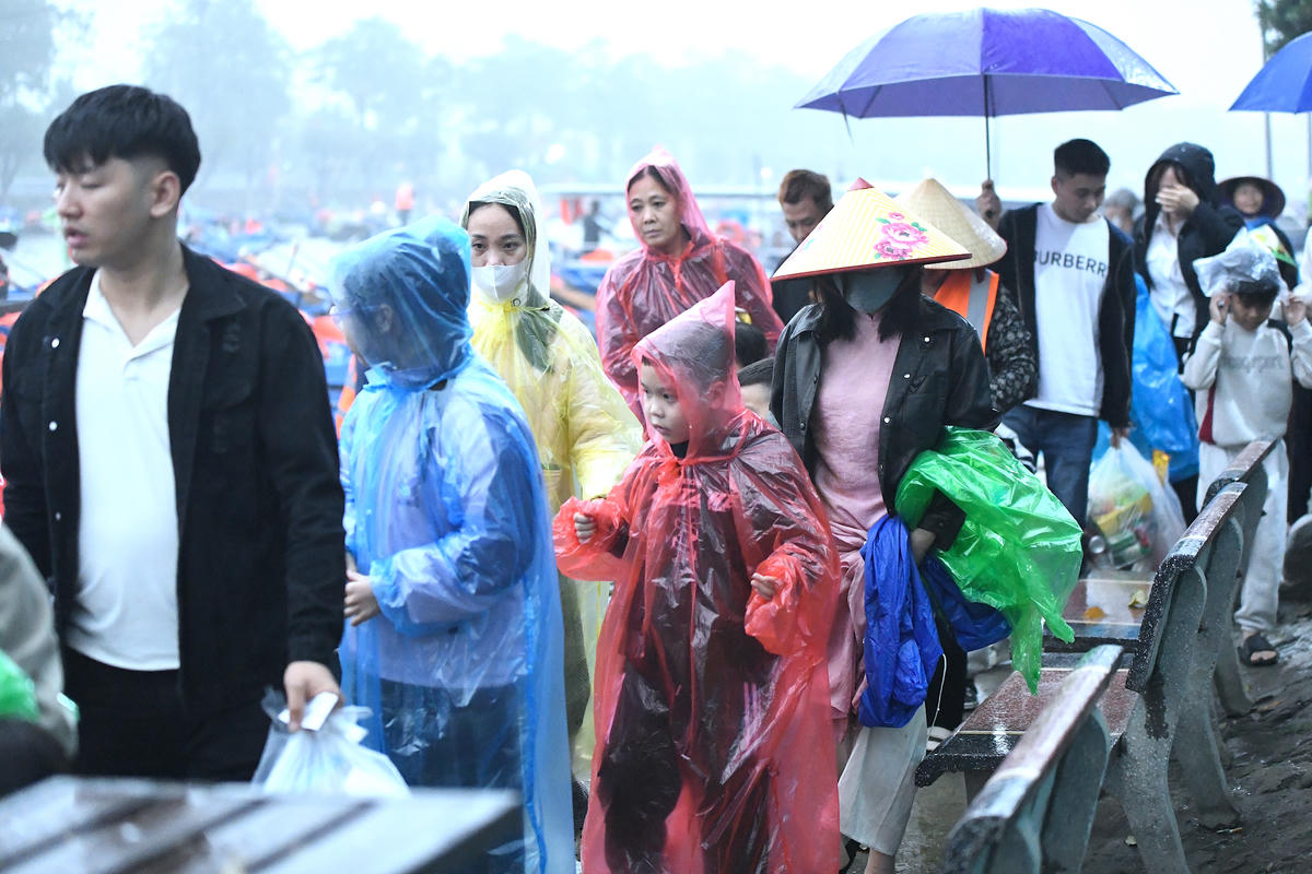 Nhiều em nhỏ đội mưa cùng cha mẹ, háo hức theo bước chân trẩy hội chùa Hương. Ảnh: Phạm Sỹ.. 