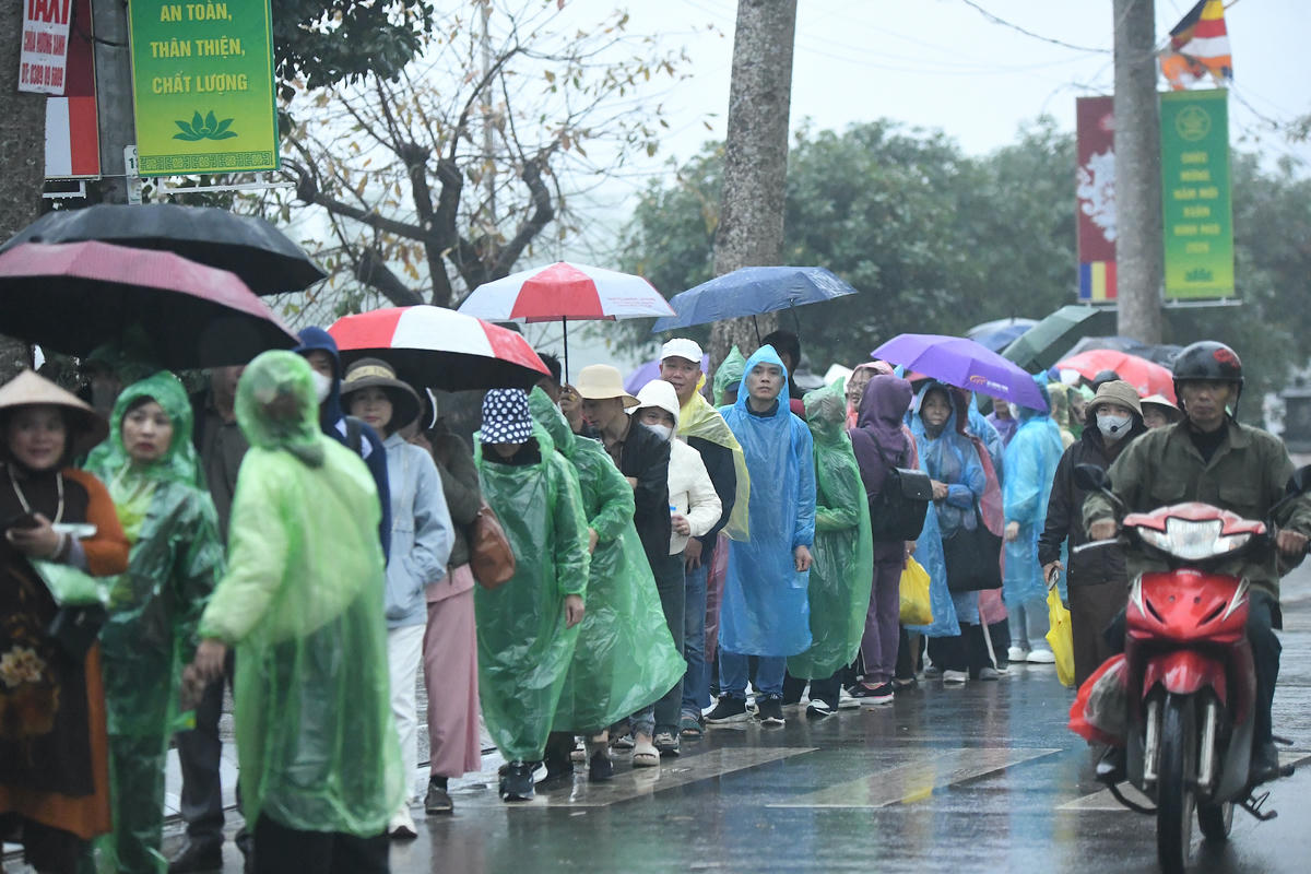 Hàng dài du khách đội mưa chờ xuống. Ảnh: Phạm Sỹ.