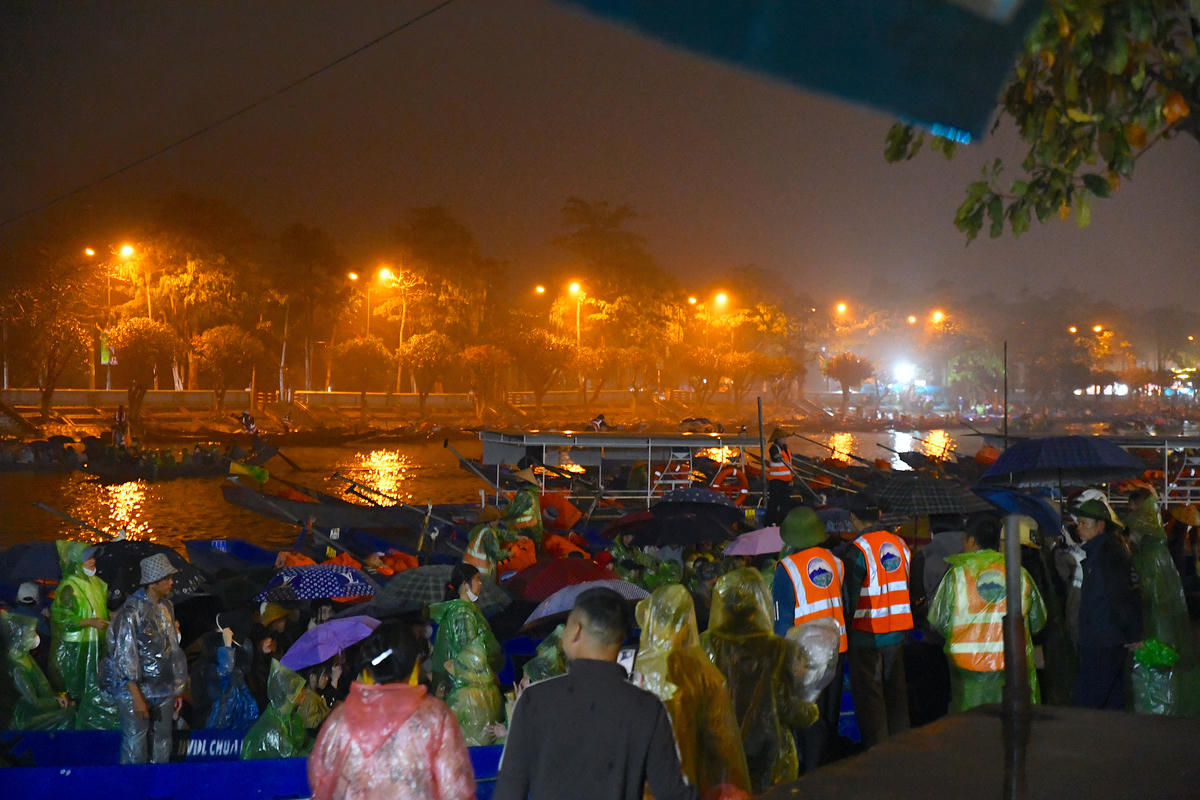 Ngay từ tờ mờ sáng, bất chấp mưa xuân, du khách tập trung tại bến đò để vào khu di tích chùa Hương dự lễ khai hội. Ảnh: Phạm Sỹ.