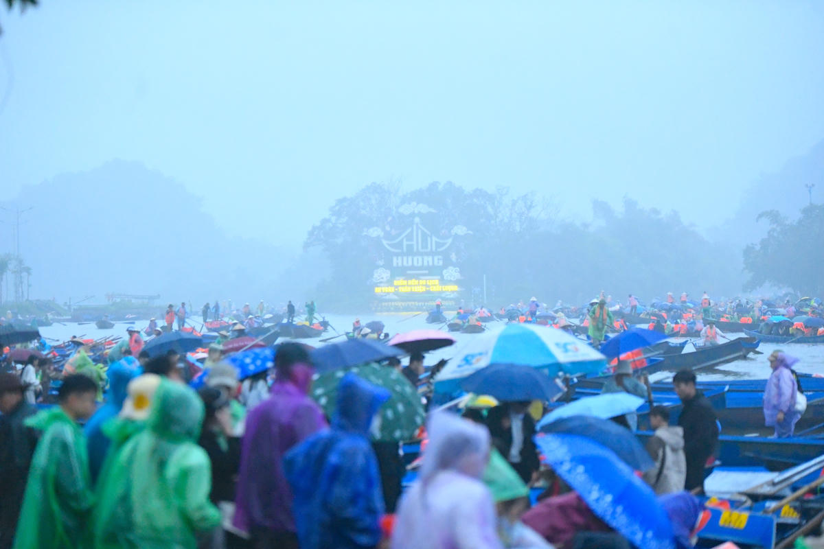 Dù mưa lớn dần từ sáng sớm, lượng khách hành hương về chùa Hương vẫn không ngừng tăng. Ảnh: Phạm Sỹ.. 