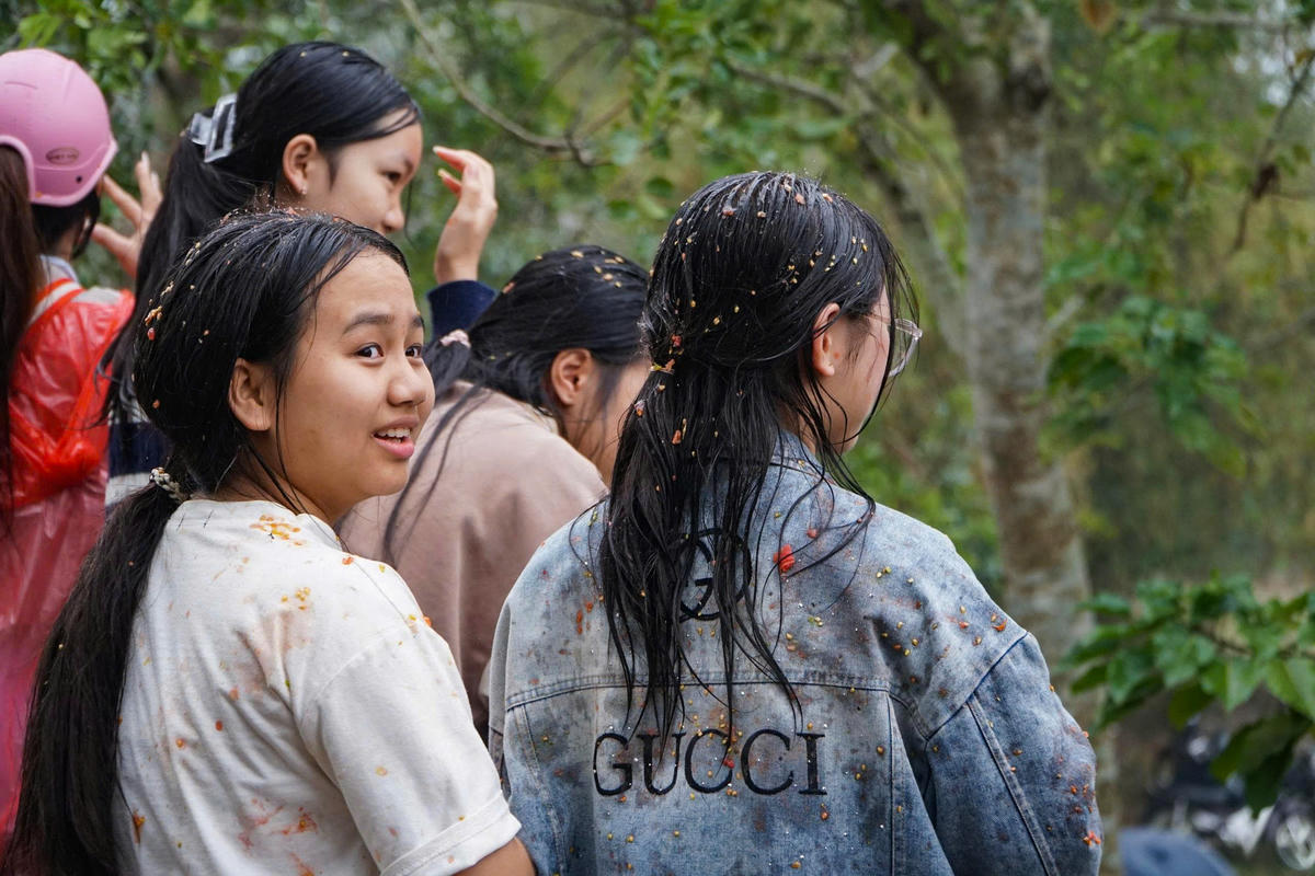 Chỉ sau ít phút, áo quần, tóc tai của người tham gia đã nhuộm màu cà chua, nhưng trên gương mặt ai cũng ánh lên niềm vui. Ảnh: Đình Minh