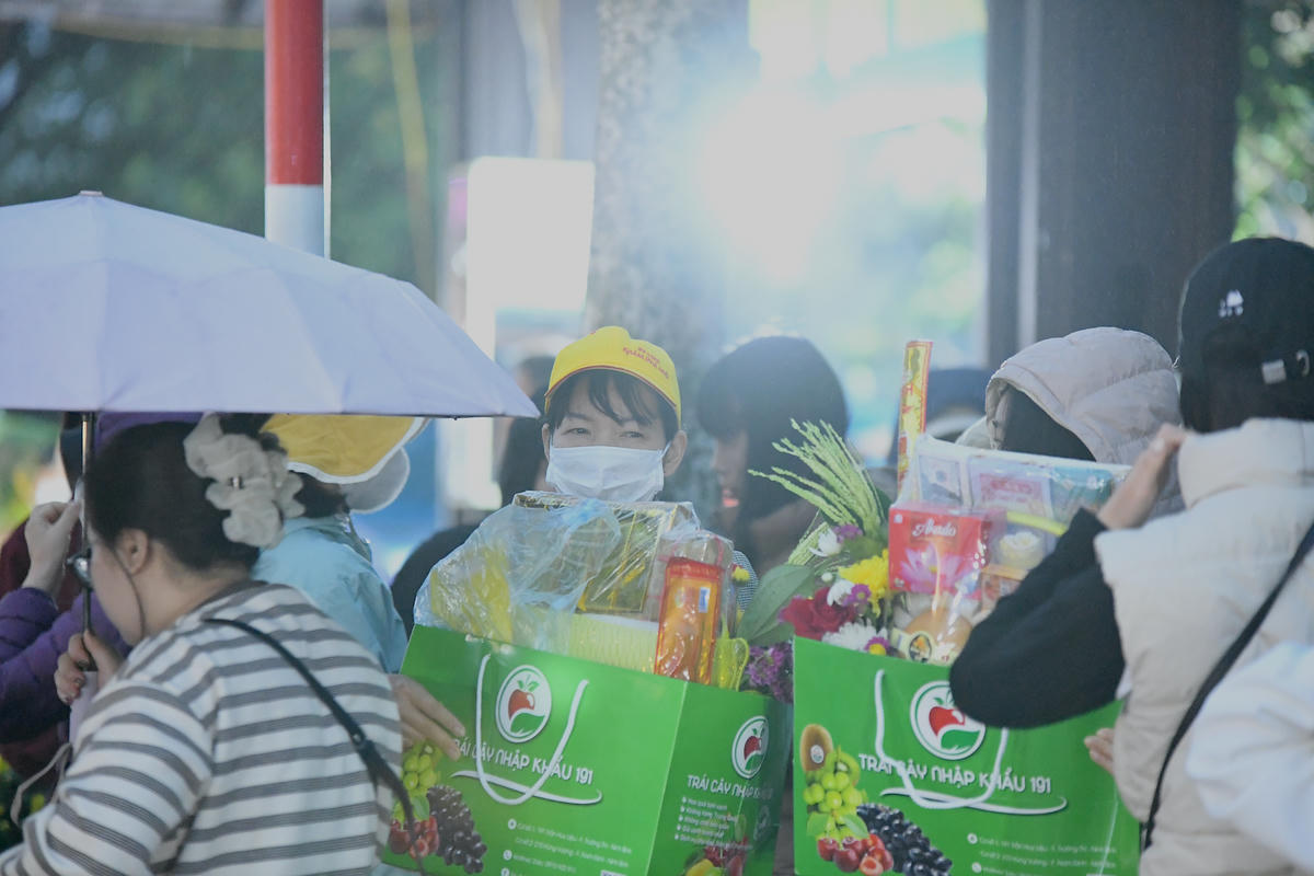 Trong mưa xuân, du khách thập phương mang theo lễ vật, thành tâm về chùa Hương hành lễ. Ảnh: Phạm Sỹ.