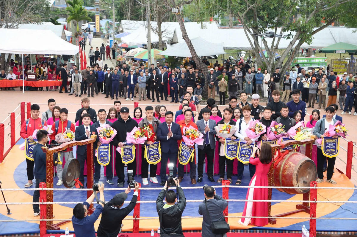 Ban tổ chức trao cờ lưu niệm cho các đơn vị tham gia lễ hội Vật cổ truyền làng Vĩnh Khê. Ảnh: VC.