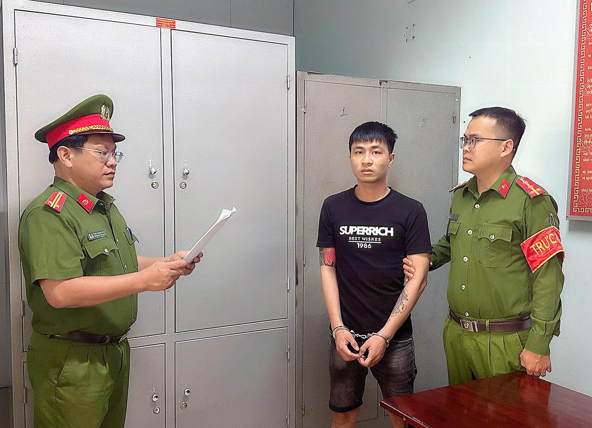 Công an phường Điện Bàn Đông đọc quyết định bắt Phan Hồng Thiện. Ảnh: CA Điện Bàn Đông.