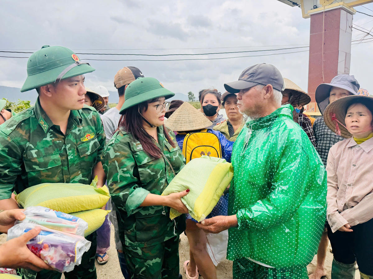 Nhà báo Thanh Nga cùng Bộ đội Biên phòng Đắk Lắk tặng quà động viên bà con vùng lũ. Ảnh: BP.