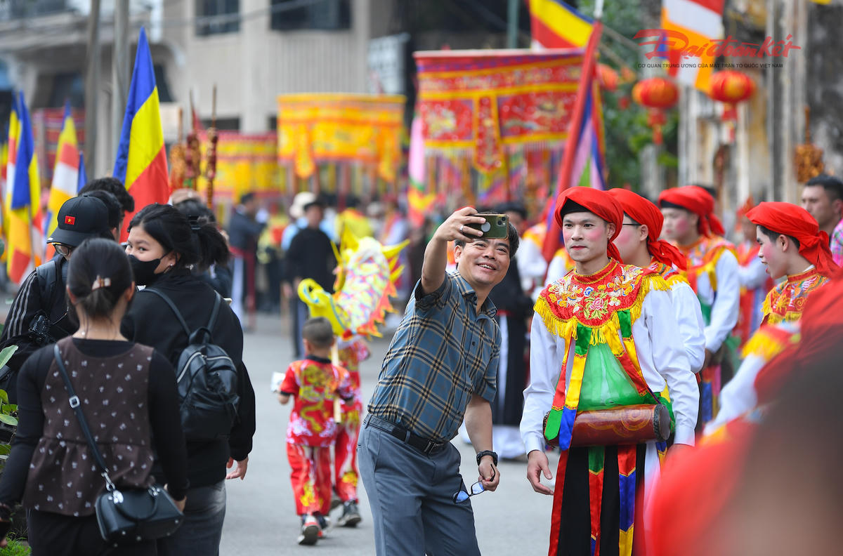Du khách lưu lại kỷ niệm đẹp cùng “con đĩ” trong đội múa bồng. Ảnh: Phạm Sỹ.