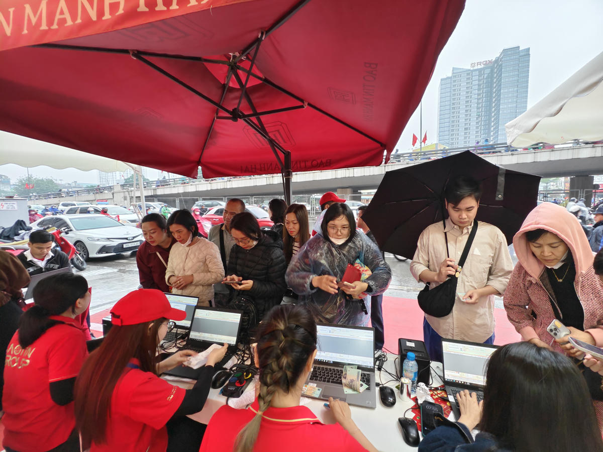 Người dân đội mưa mua vàng cầu may.