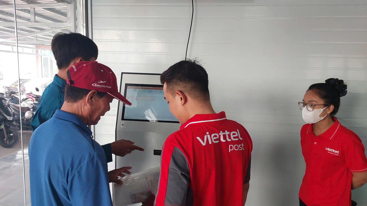 Người dân được nhân viên hướng dẫn nộp hồ sơ trực tuyến. Ảnh: Nguyên Du