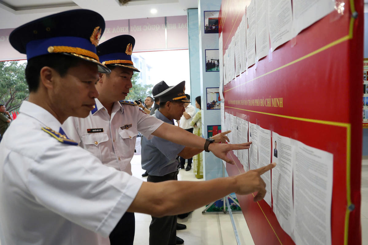 Cán bộ, chiến sĩ Hải quân Vùng 2 đọc thông tin trước khi tham gia bầu cử. Ảnh: Mạnh Cường.
