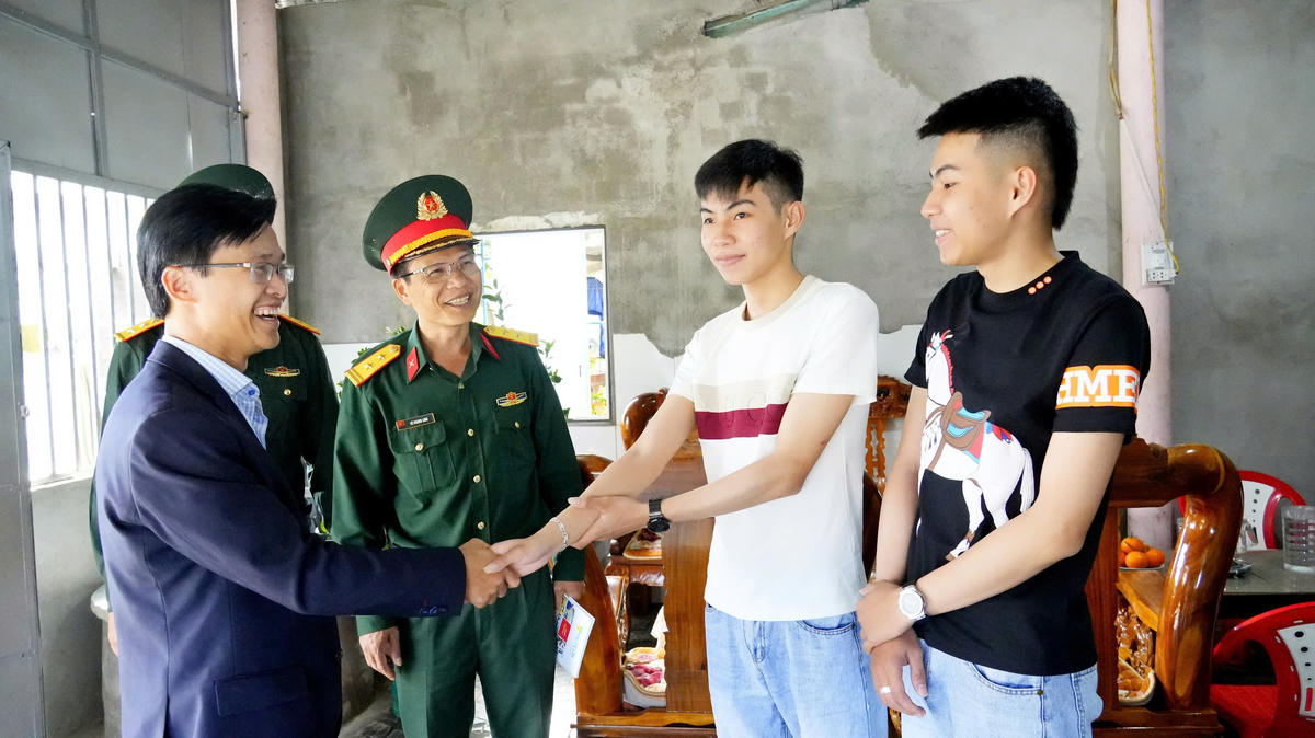 Ông Ung Đình Hiền (bên trái), Chủ tịch UBND xã Vạn Tường thăm hỏi hai anh em Lâm Hoàng Mạnh và Lâm Hoàng Cường. Ảnh: CV.