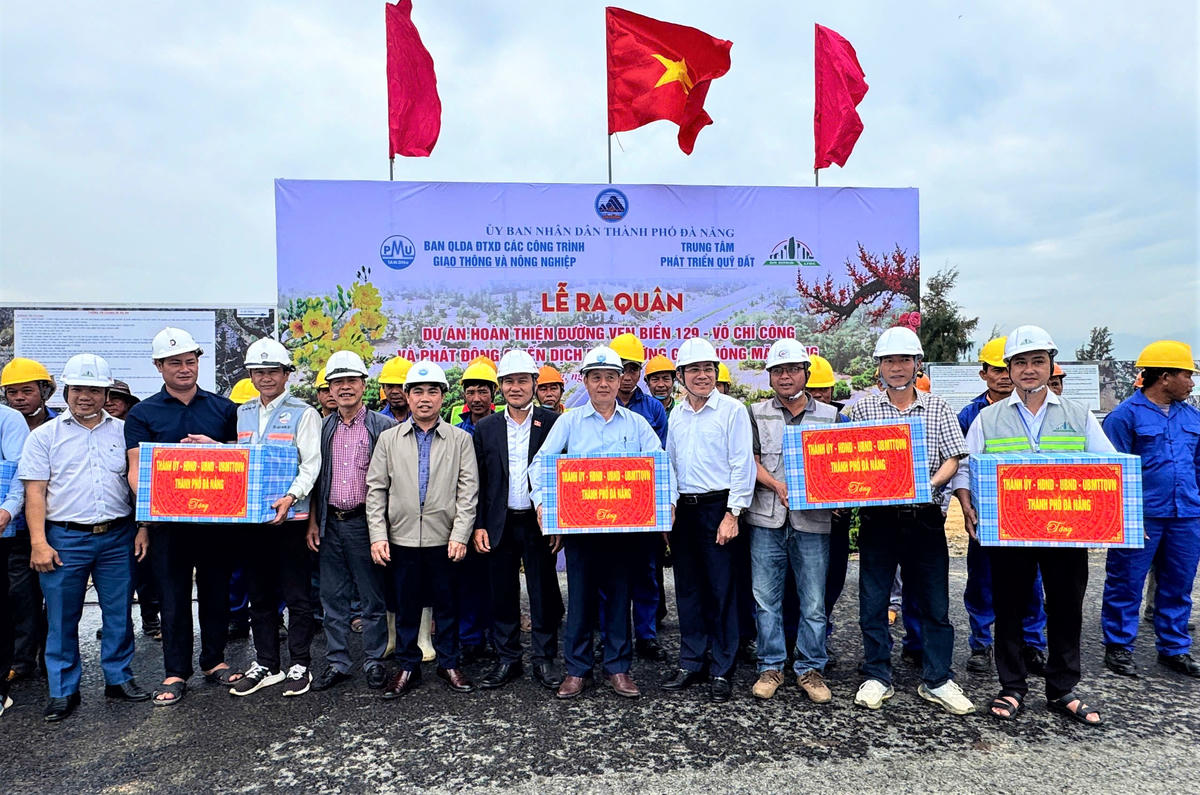 Phó Bí thư thường trực TP Đà Nẵng Nguyễn Đình Vĩnh (bên trái, áo&nbsp;vêt xanh) tặng quà cho đơn vị thi công. Ảnh: Nguyễn Tín.