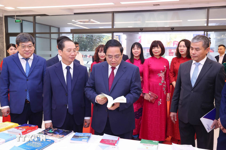 Thủ tướng Phạm Minh Chính và các đại biểu tham quan khu trưng bày sách và giới thiệu về các hoạt động của Học viện. (Ảnh: Văn Điệp/TTXVN)