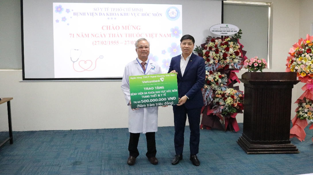 Đồng chí Hồng Quang - Thành viên HĐQT, Chủ tịch Công đoàn Vietcombank (bên phải) trao biển tượng trưng hỗ trợ 500 triệu đồng cho Bệnh viện Đa khoa Khu vực Hóc Môn.