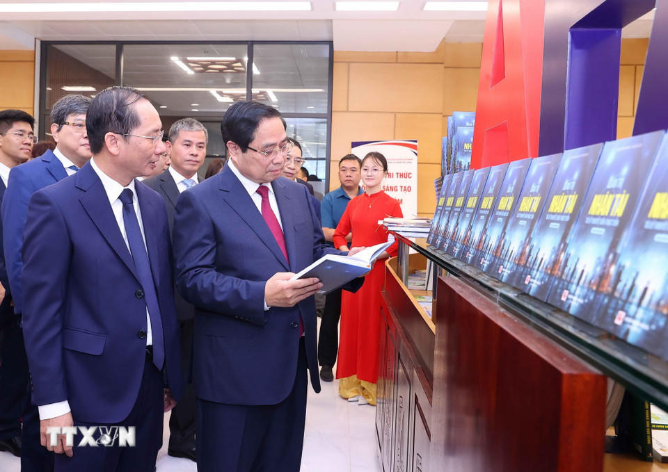 Thủ tướng Phạm Minh Chính và các đại biểu tham quan khu trưng bày sách và giới thiệu về các hoạt động của Học viện. (Ảnh: Văn Điệp/TTXVN)