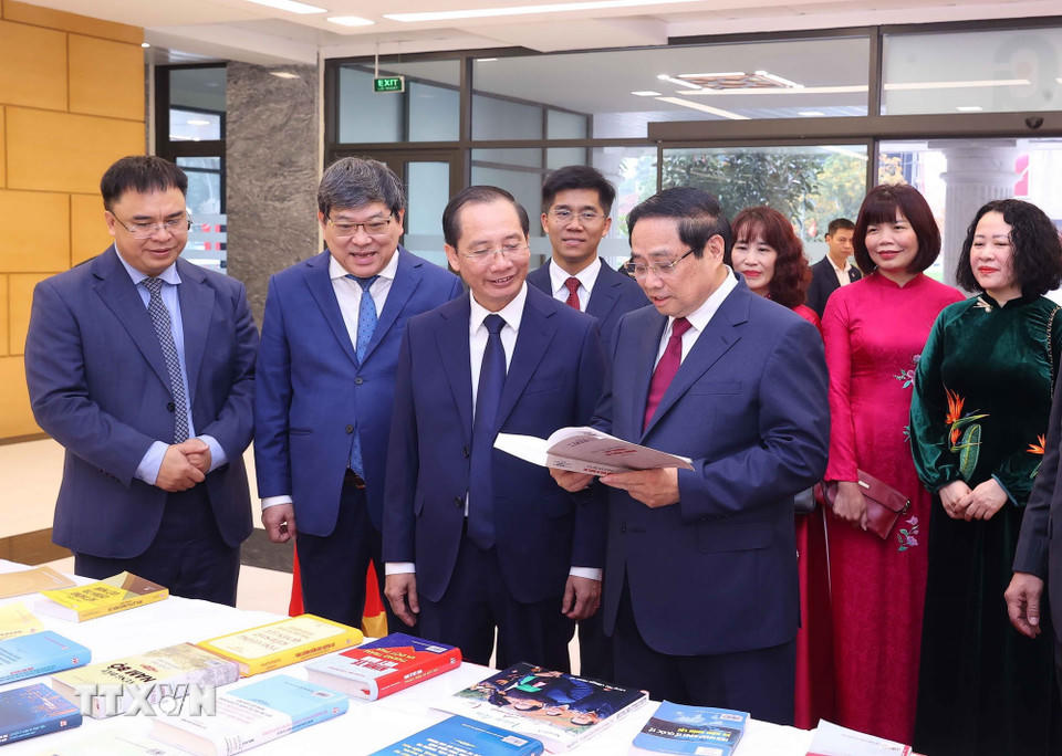 Thủ tướng Phạm Minh Chính và các đại biểu tham quan khu trưng bày sách và giới thiệu về các hoạt động của Học viện. (Ảnh: Văn Điệp/TTXVN)