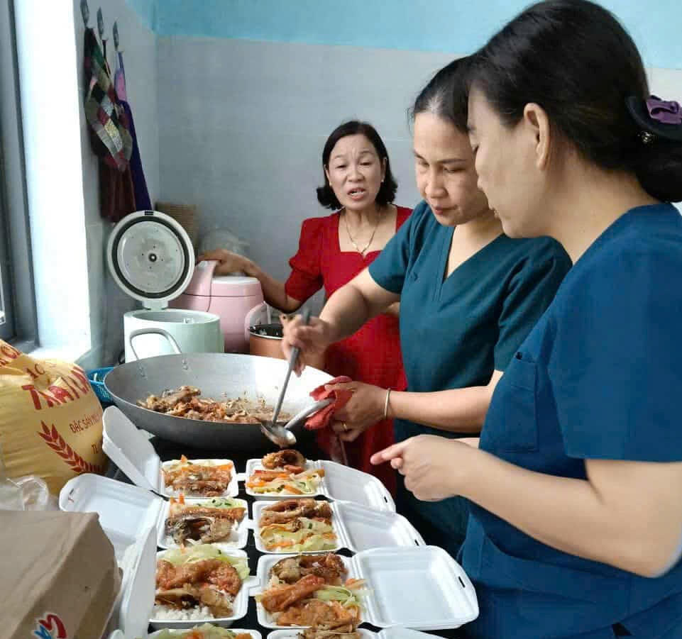 Hội thiện nguyện Nam Giang cùng y, bác sĩ của TTYT KV Nam Giang chuẩn bị những suất cơm miễn phí cho bệnh nhân. Ảnh: CV.