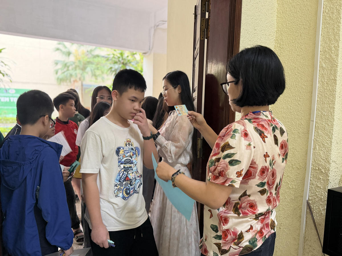 Cán bộ coi thi kiểm tra thông tin thí sinh trước khi vào phòng thi. Ảnh: Nguyễn Hoài