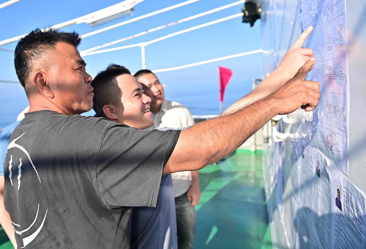 Các cử tri trên tàu Hải An 68 tìm hiểu thông tin về các ứng viên Đại biểu Quốc hội và ứng viên Hội đồng nhân dân TP Hồ Chí Minh trước khi bỏ phiếu. Ảnh: Văn Đường.