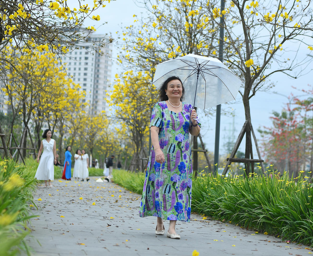 Người dân thong thả tản bộ, tận hưởng không khí trong lành dưới hàng cây đang mùa nở rộ.. 