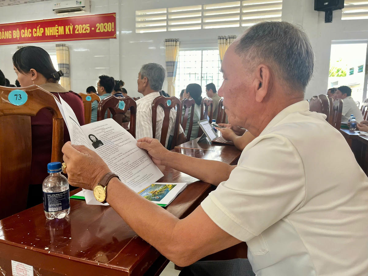 Cử tri Nguyễn Văn Chấn xem&nbsp;thông tin về tiểu sử của bà Nguyễn Quỳnh Liên. Ảnh: Thanh Tiến.