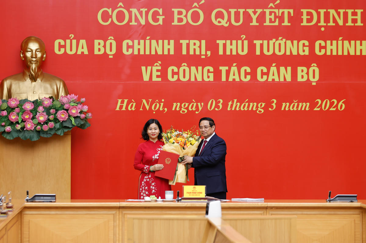 Thủ tướng Phạm Minh Chính tặng hoa chúc mừng đồng chí Nguyễn Thị Tuyến. Ảnh: Nhật Bắc