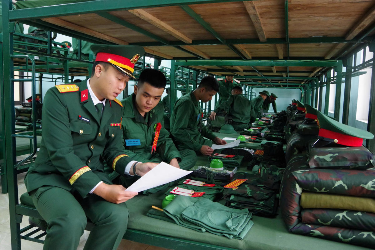 Cán bộ Tiểu đoàn bộ binh 43, Trung đoàn bộ binh 842 hướng dẫn chiến sĩ nhập ngũ năm 2026 về huấn luyện, học tập tại đơn vị. Ảnh: QSQT.