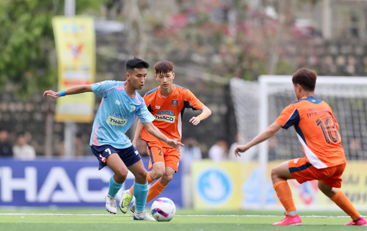 Pha tranh chấp giữa đồi bóng chủ nhà snh viên Trường Đại học Nha Trang và trườngCĐ FPT Polytechnic trong trận khai mạc (ảnh Thùy Trang)