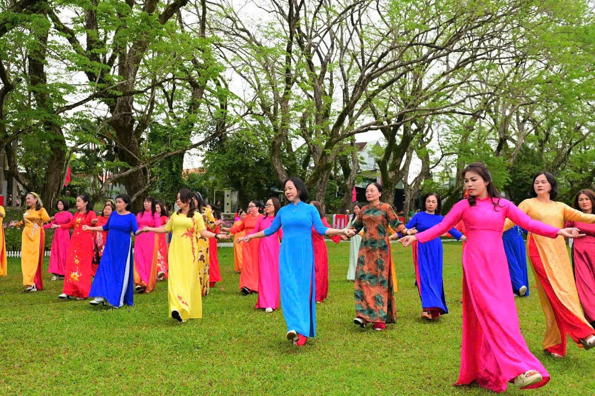 Những phụ nữ trong trang phục áo dài trình diễn dân vũ. Ảnh: CV.