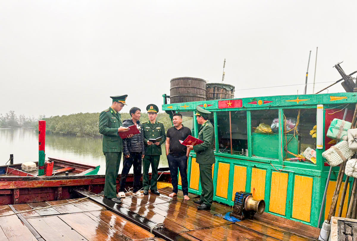Cán bộ biên phòng xuống tàu tuyên truyền, phổ biến thông tin về ngày hội bầu cử cho ngư dân.