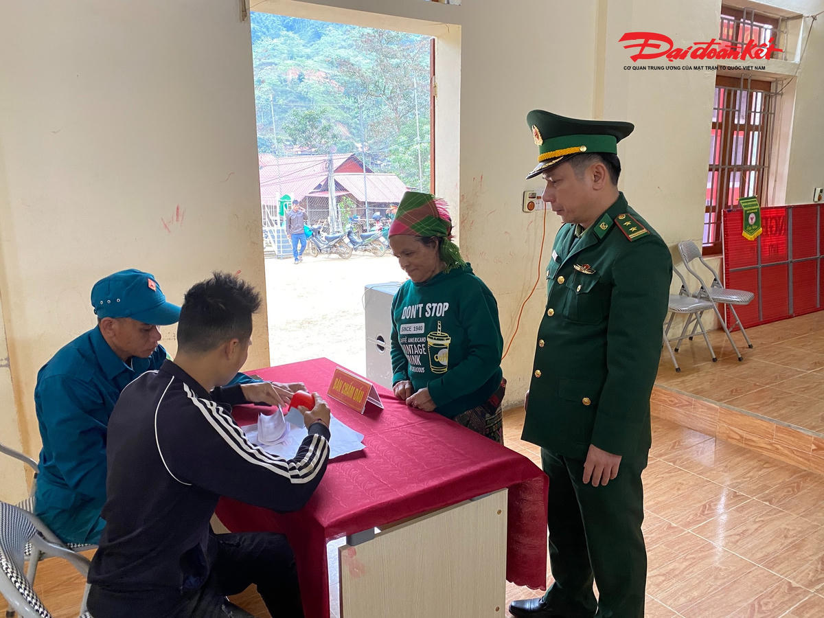 Cán bộ đồn Biên phòng Na Ngoi và thành viên tổ bầu cử bản Huồi Thum hướng dân cử tri bỏ phiếu. Ảnh: LT