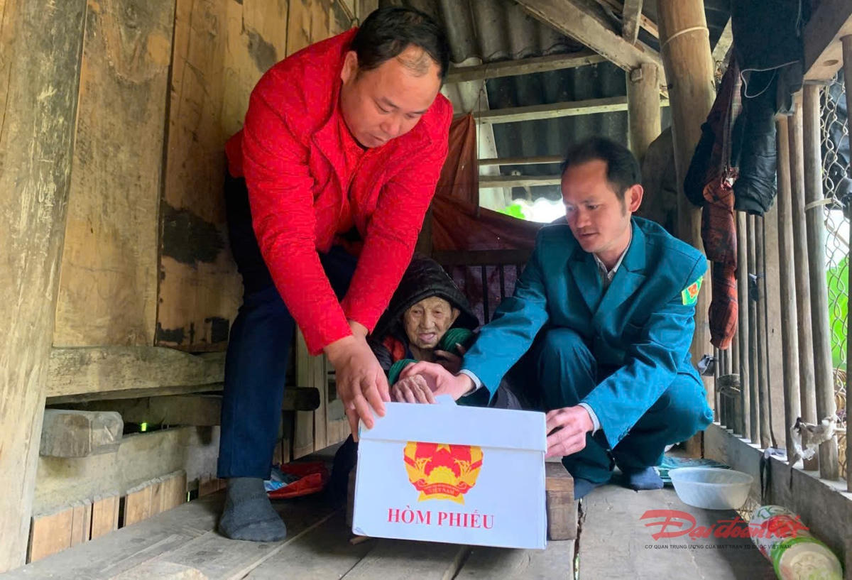 Cán bộ xã hướng dẫn bà Hoàng Thị Tồng bỏ phiếu.