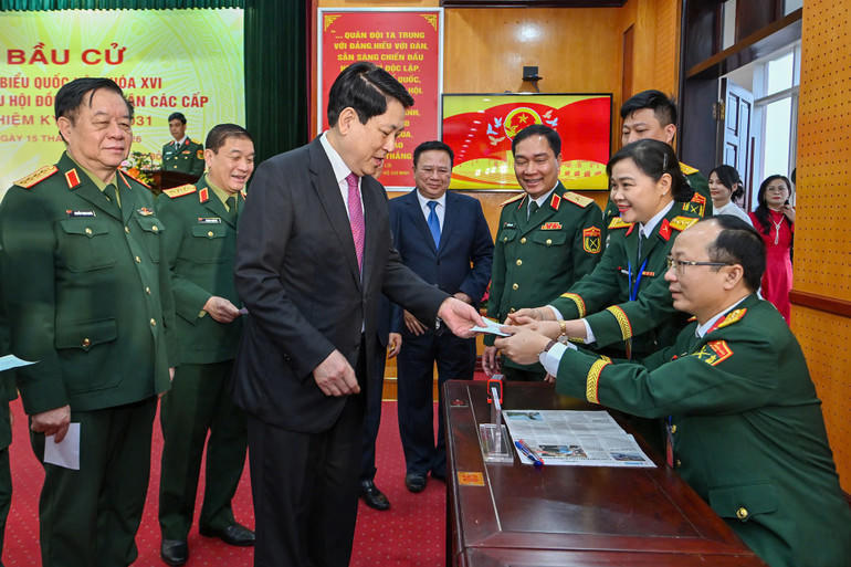 Tổ bầu cử triển khai đóng dấu "đã bỏ phiếu" vào thẻ cử tri. (Ảnh: THỦY NGUYÊN)