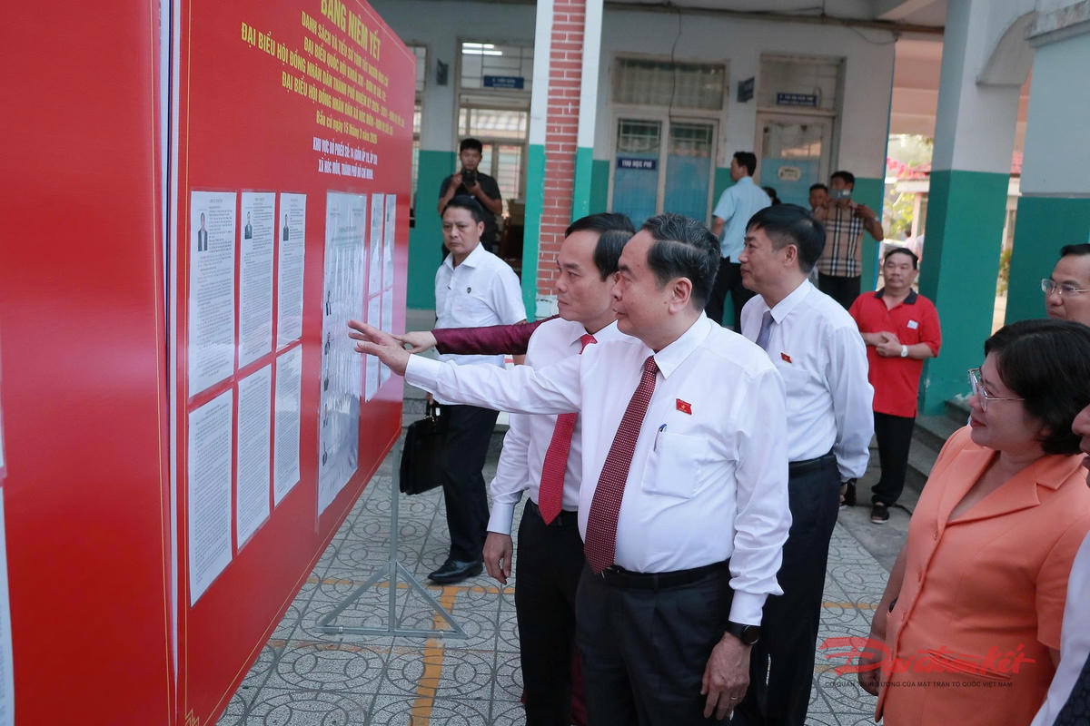 Chủ tịch Quốc hội Trần Thanh Mẫn và các cử tri đọc thông tin ứng viên tại điểm bỏ phiếu xã Hóc Môn, TP Hồ Chí Minh. Ảnh: Hồng Phúc.