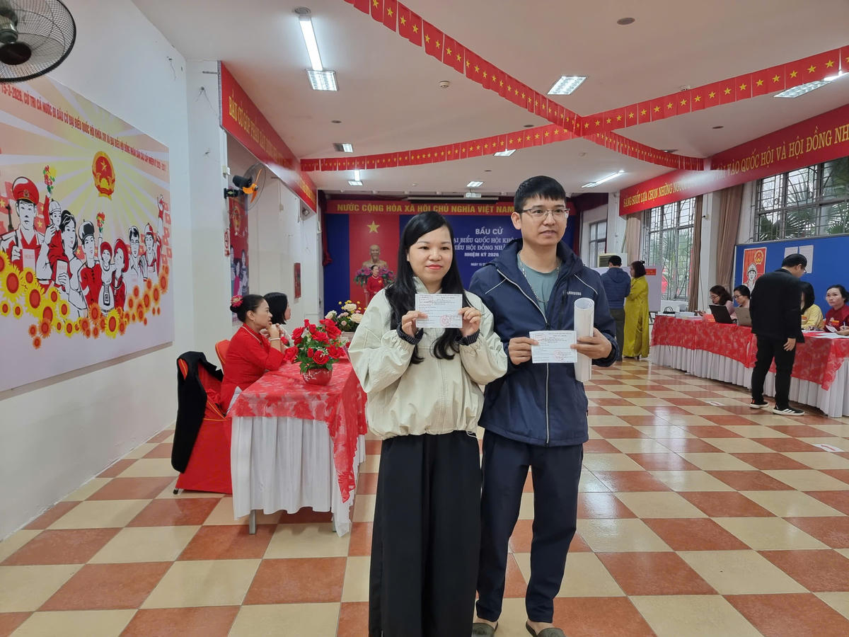 Hai vợ chồng chị Sen, anh Mạnh sau khi bỏ phiếu với tấm thẻ cử tri đã được đóng dấu. Ảnh: Xuân Cường.