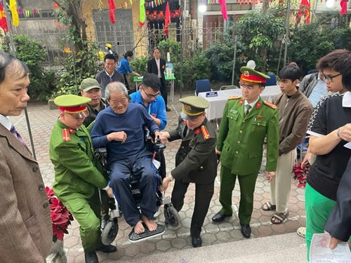 Công an Hà Nội hỗ trợ cử tri lớn tuổi bỏ phiếu.