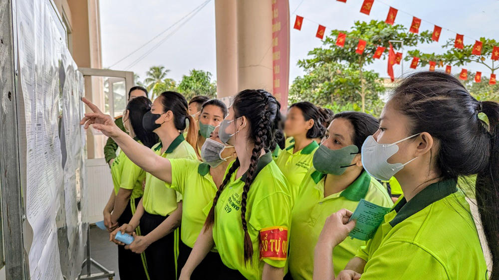 Cử tri là học viên đang điều trị cai nghiện tại cơ sở xem bảng tóm tắt tiểu sử của các ứng viên. Ảnh: Nghiêm Túc